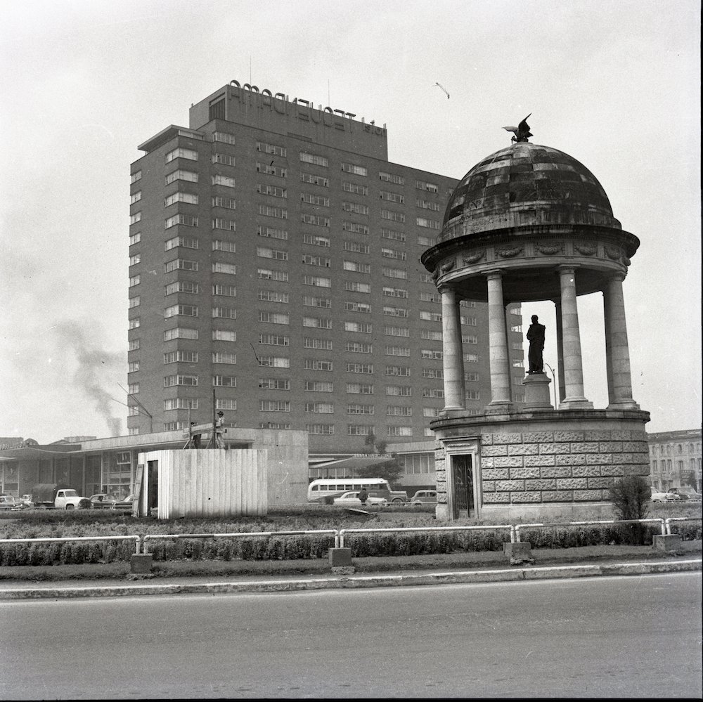 Plazoleta del Hotel Tequendama, Templete del libertador, Parque Centenario, Calle 26 entre las carreras 7 y 13, 1955-1958. Las fotografías de Caicedo registran los cambios urbanos constantes de una ciudad que se mueve entre variados impulsos modernizadores y la realidad de diversas condiciones sociales y económicas.  A ello se une, como es evidente en esta imagen, la tensión de un entramado urbano marcado por los hitos de construcción nacional y los insipientes marcadore del deseo del ingreso de la urbe a los circuitos de comercio y capital global.