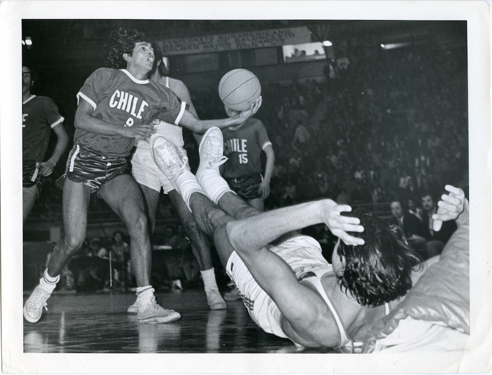 Campeonato Suramericano de baloncesto, s.f. La perspectiva, el encuadre, la puesta en escena de un espectáculo masivo en el que la imagen de Caicedo resalta, una vez más, el momento decisivo de esfuerzo y belleza plástica con el que el fotógrafo pareciera sintetizar el movimiento del deporte.