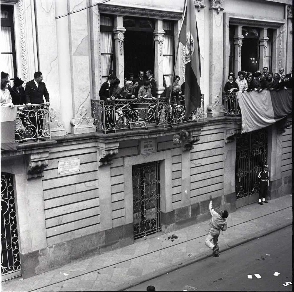 El contraste entre el podio y la calle. El podio de poder y la calle del pueblo. Foto de uno de los balcones de la Casa de Nariño en Bogotá. Alberto Lleras Camargo, presidente de Colombia entre 1958 y 1962, recibe un regalo que un hombre le lanza desde la calle. Foto tomada por Caicedo durante el mandato de Lleras Camargo.